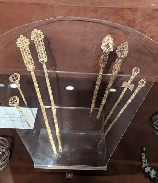 Collection of ornate gold and silver hair pins with decorative tops from ancient Macedonia